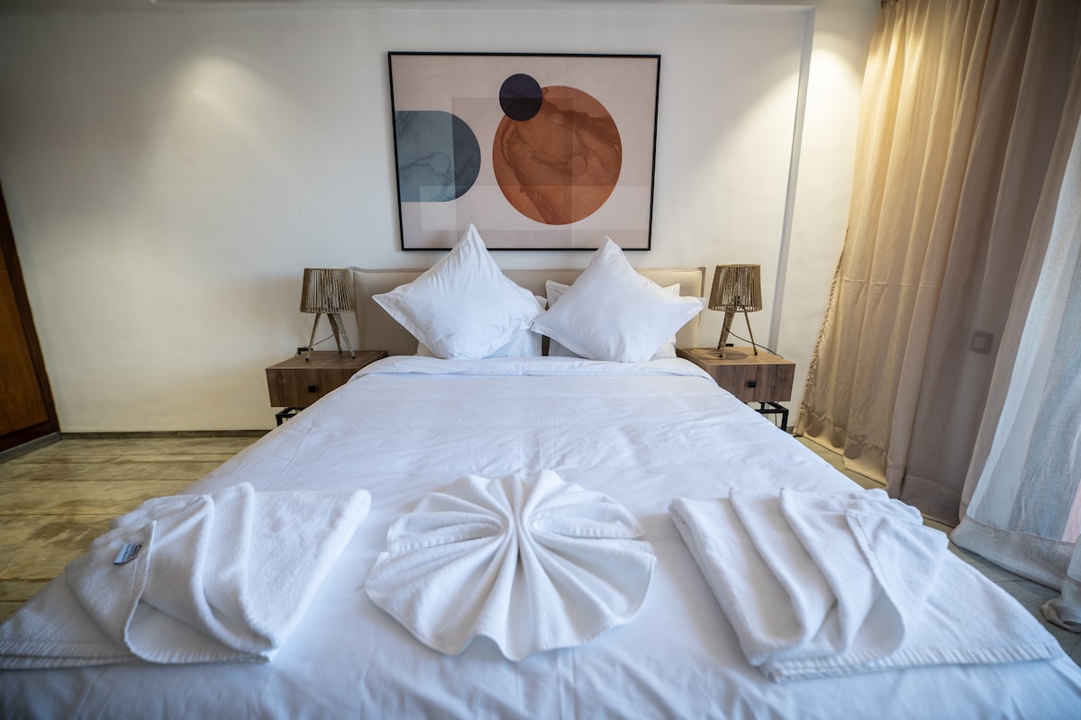 Კომფორტული საწოლი „Queen Size“, რომელიც ღიაა აივანზე.