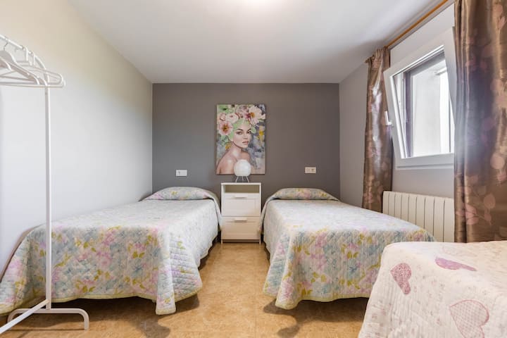 Habitación con tres camas de una persona.