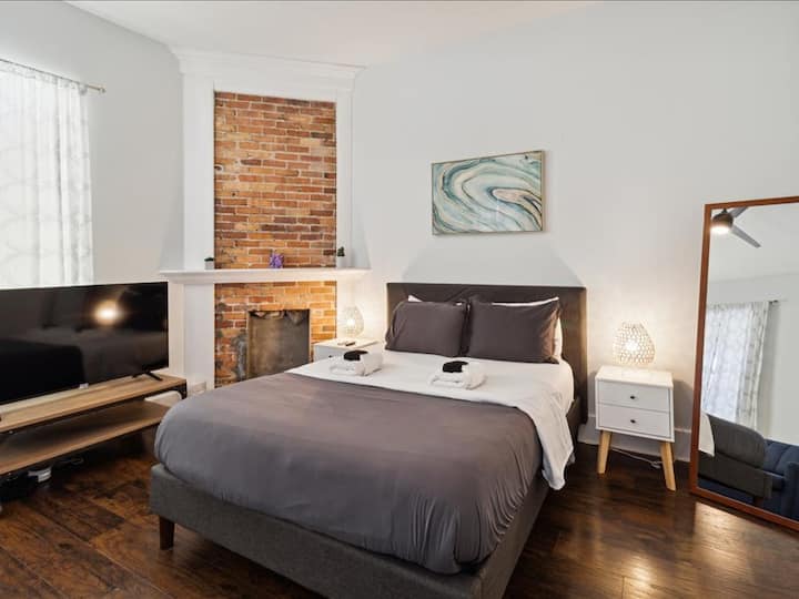 Zen Room is a private bedroom with a decorative brick fireplace, queen bed w/ 12" Zinus Green Tea memory foam mattress, soft, 400 thread count sheets, a full-size mirror, and a flat-screen Roku smart TV with Netflix.