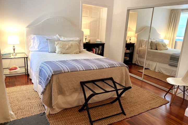 חדר שינה זוגי מואר עם שפע של מקום אחסון.