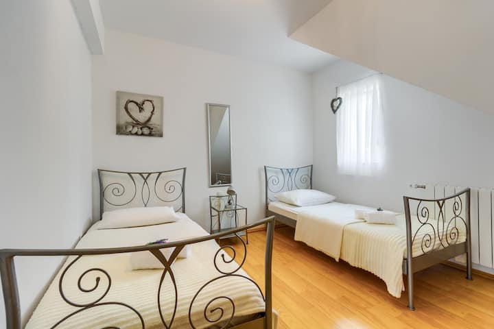 一楼设有两张单人床的卧室，可欣赏后院和泳池景观