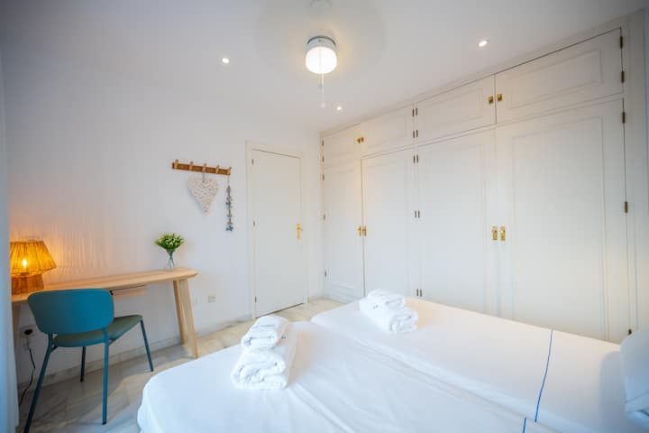 Deux lits simples, un bureau et des armoires encastrées spacieuses dans la chambre principale