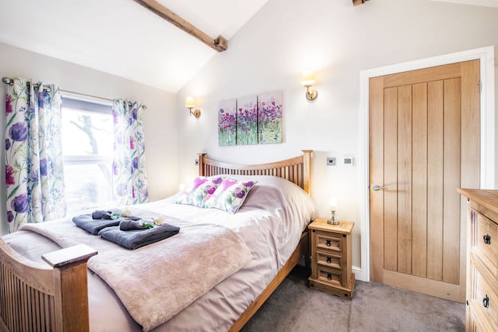 غرفة نوم مريحة بسرير وتلفزيون بمقاس كبير