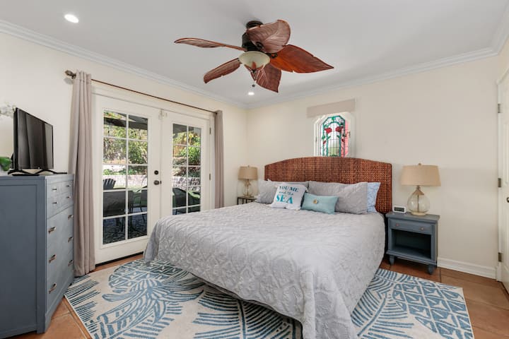 La chambre du rez-de-chaussée avec salle de bains privative avec portes-fenêtres donnant sur l'arrière-cour.