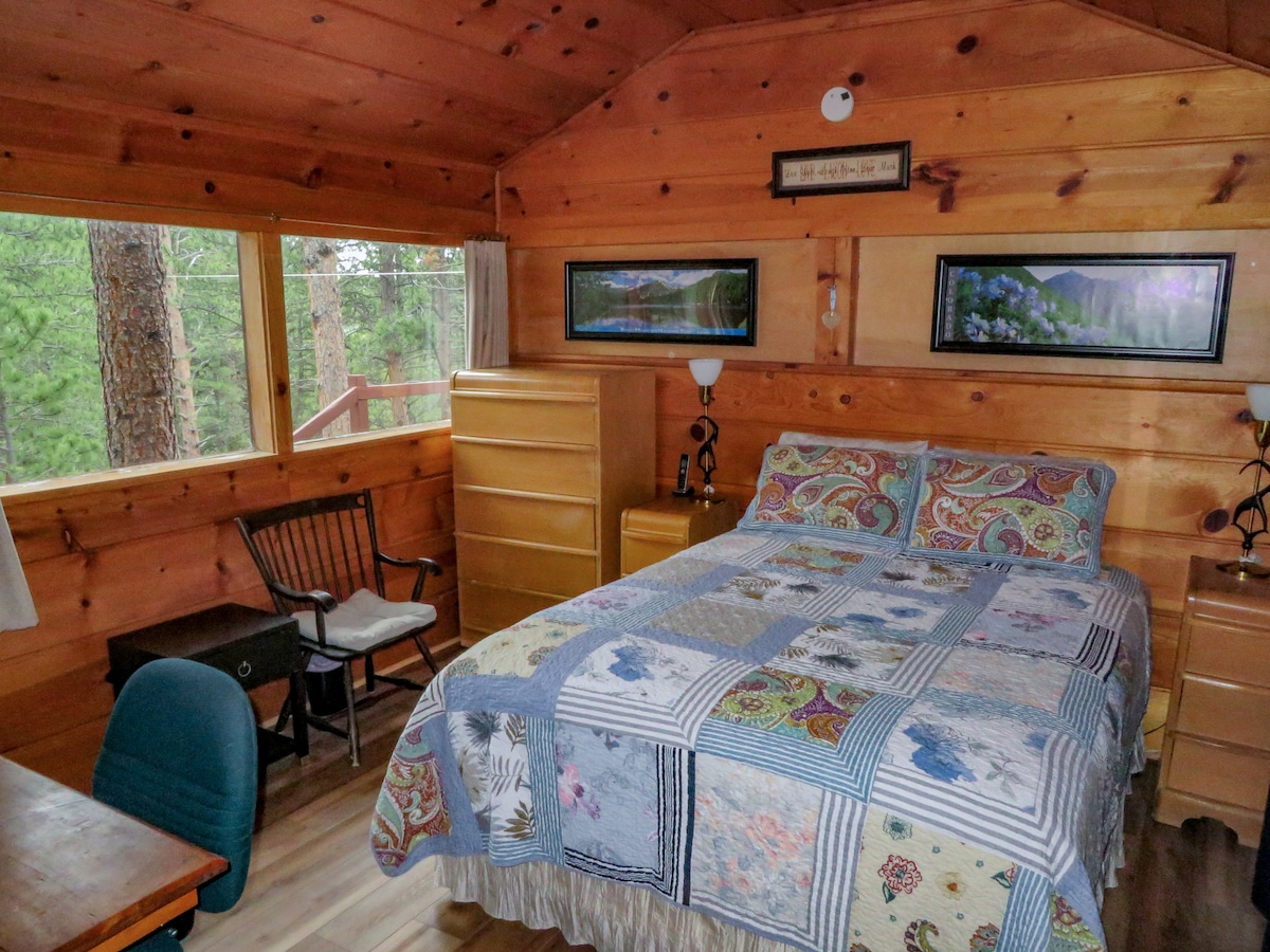 Primary Bedroom with queen bed and large windows - Mountainbrooks Ranch Aspen Cabin