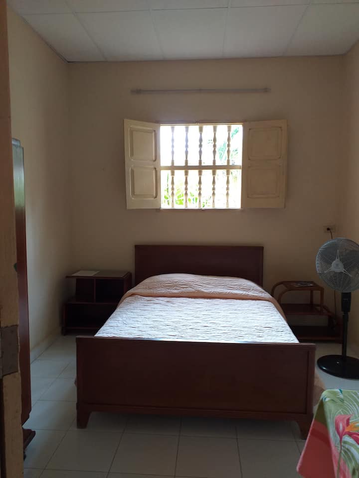 Dhomë në katin përdhes me krevat dopio dhe ventilator.