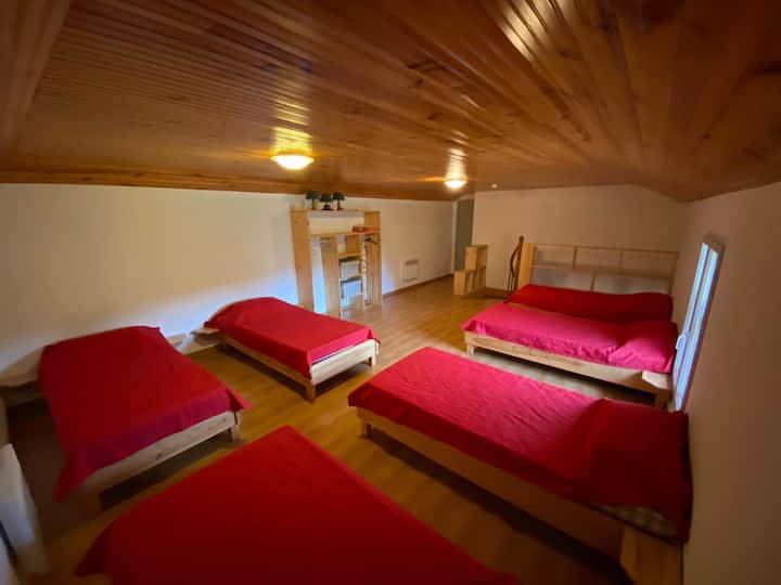 un dormitorio en el piso de arriba con seis camas individuales.