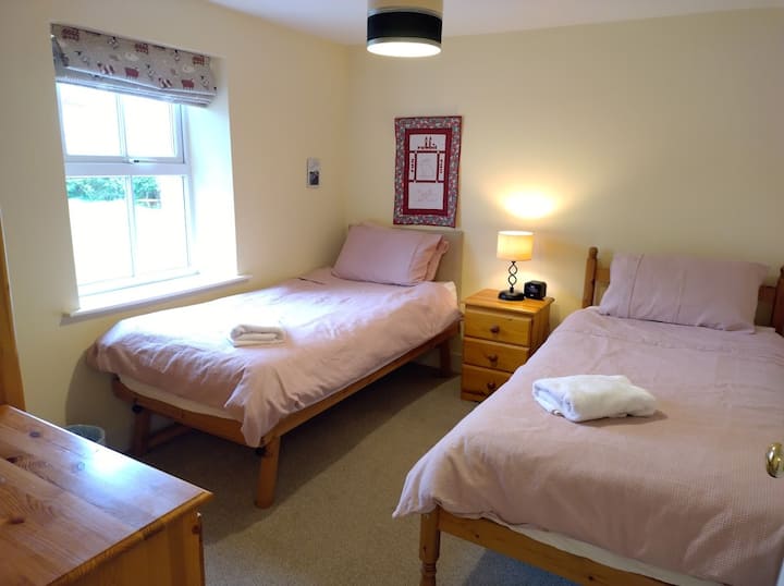 Spavaća soba s 2 odvojena kreveta, ormarom i komodom uz krevet