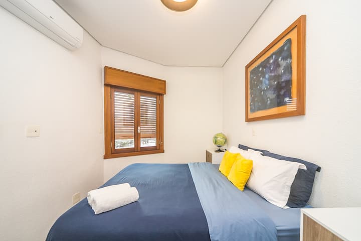 חדר שינה עם מיטת קווין סייז, מיזוג אוויר, חלונות אטומים לרעש ותריסי האפלה מובנים בחלון העץ, כמו גם מראה ומתלה בגדים.