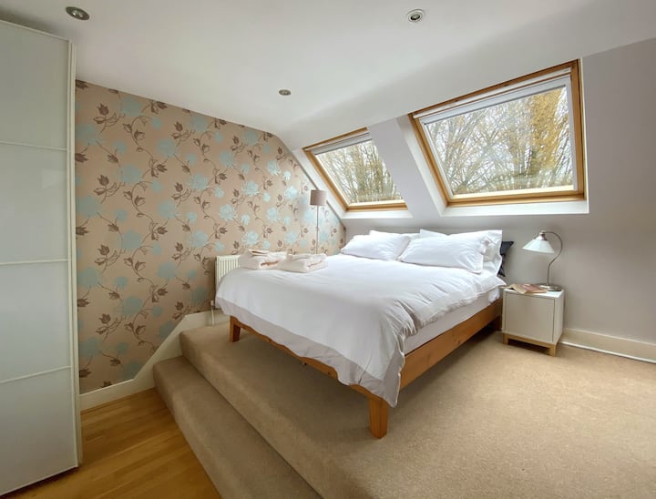 Dormitorio superior con escritorio en el lateral y  descansillo con armario y tumbona. La habitación es muy luminosa incluso en los días más grises y es encantadora para la perezosa por la tarde. El baño más pequeño con cabina de ducha está al lado.