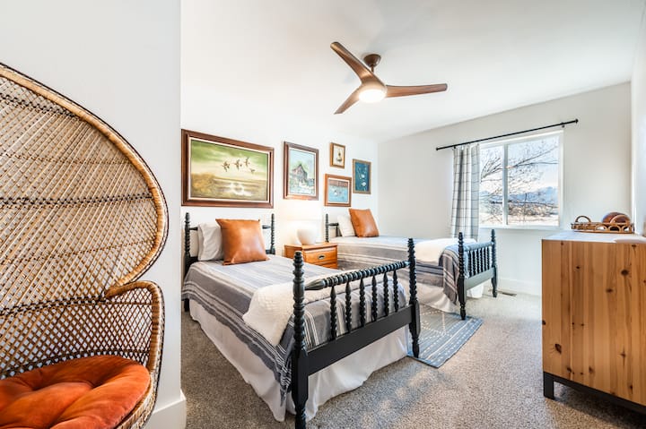 Second level bedroom with 2 twin beds, a closet, and a chair. 