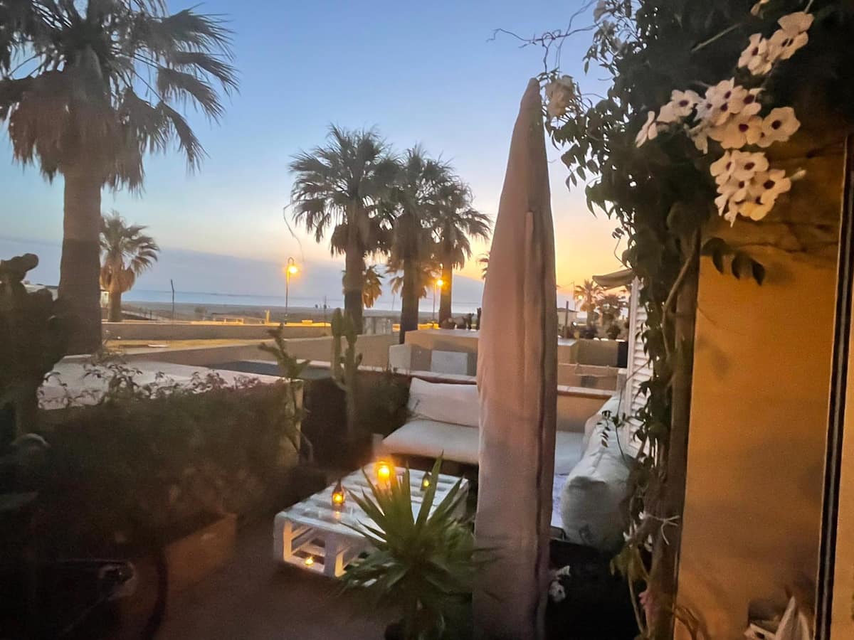 Terraza de Casa Tarifa al atardecer con vistas al paseo marítimo de Tarifa