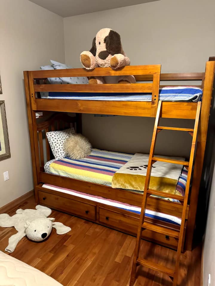 楼下4号卧室配有双层床和全尺寸床，还有一张从双层床底部滑出的铝制床 