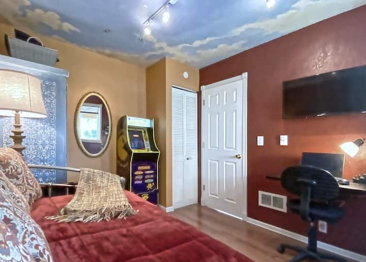 Pequeño dormitorio/sala de juegos en el piso principal con una configuración de cama individual y escritorio de la estación de trabajo.