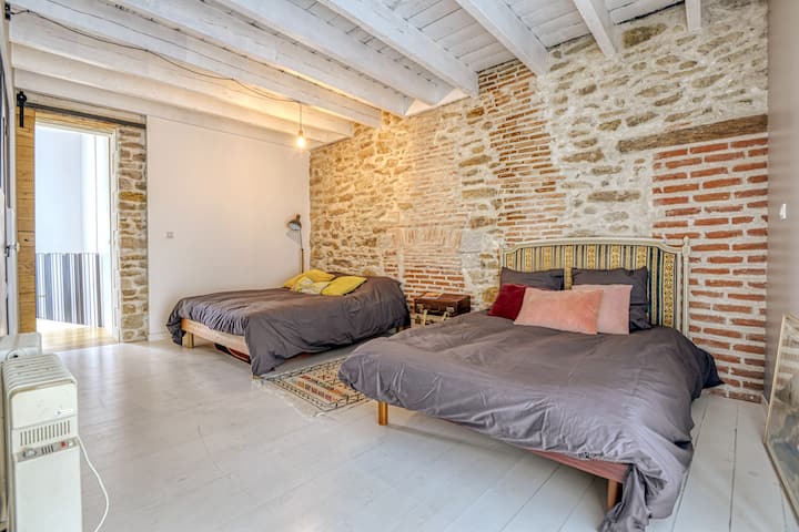 El primer dormitorio con dos camas dobles
Suelo de madera, piedras y ladrillos a la vista, techo de madera pintado