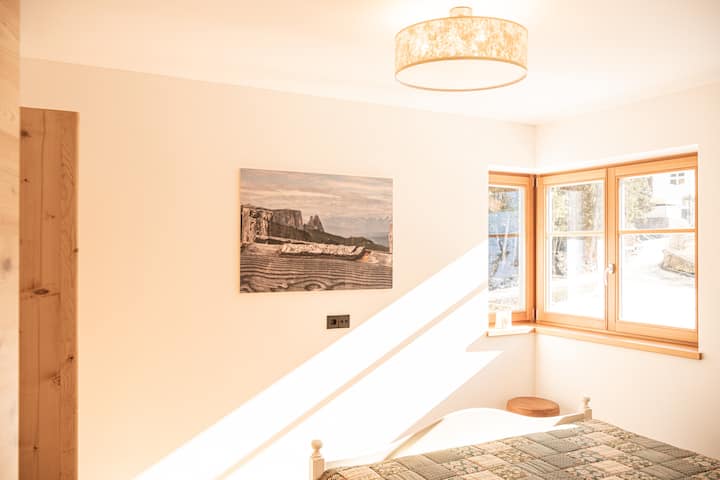 Helles Schlafzimmer mit antikem Kasten, es ist ein Doppelbettzimmer