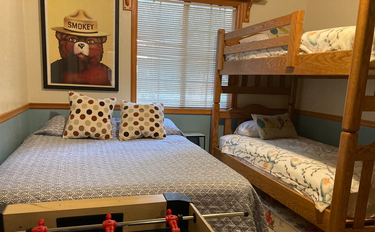 The Bunk Room - a queen bed and two twin single bunk beds are ready for the campers!  View of hill side and tree forest. 
Foosball game in here, we call it the game room.  Get ready for fun! 
