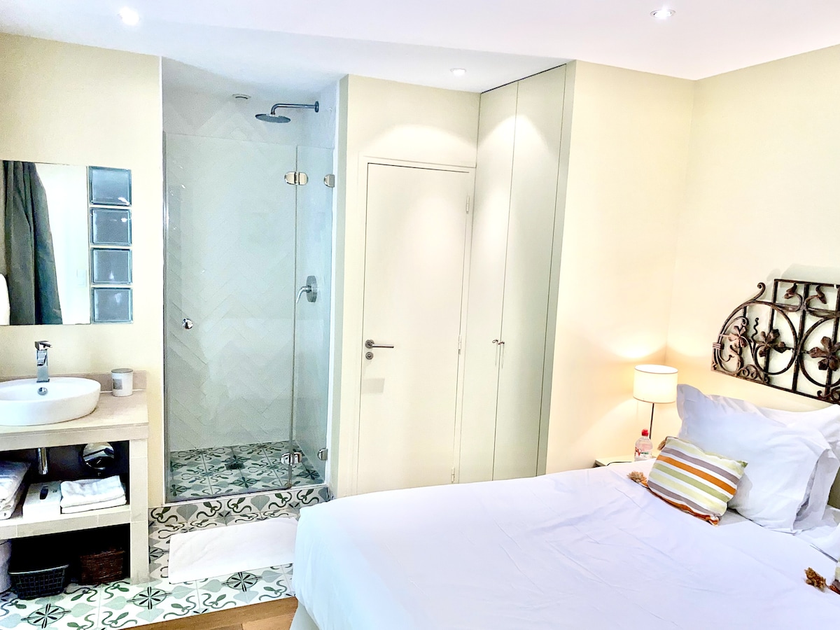 
Prvá spálňa s manželskou posteľou Queen, ktorá vedie k kúpeľni s elegantnou talianskou sprchou.