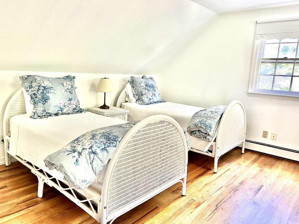 Spavaća soba na drugom katu s dva odvojena kreveta, kutkom za radnim stolom i pogledom na bazen