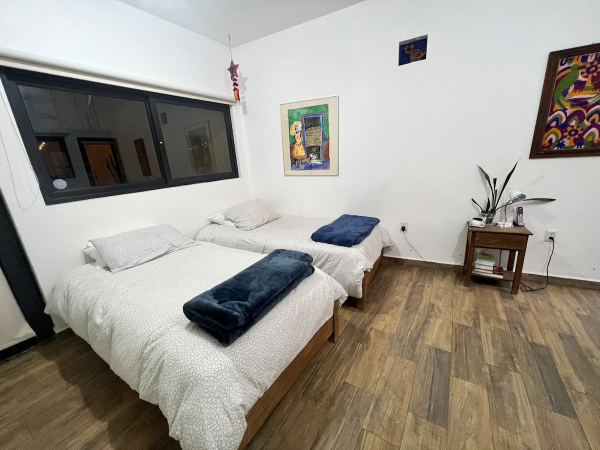 Tercer dormitorio con dos camas individuales y escritorio.