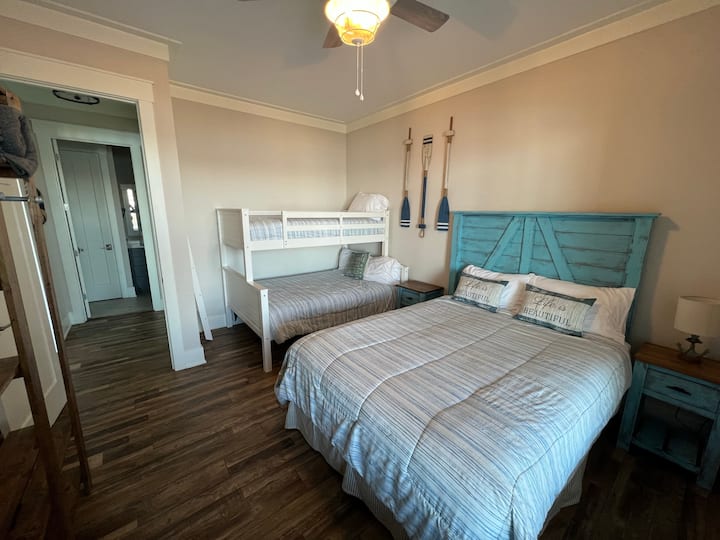 Dormitorio con cama tamaño queen y litera en el sótano.