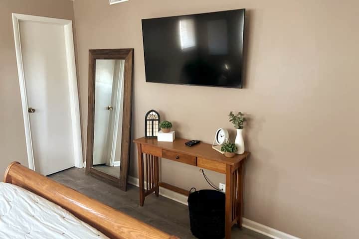 Smart TV and full length mirror in bedroom