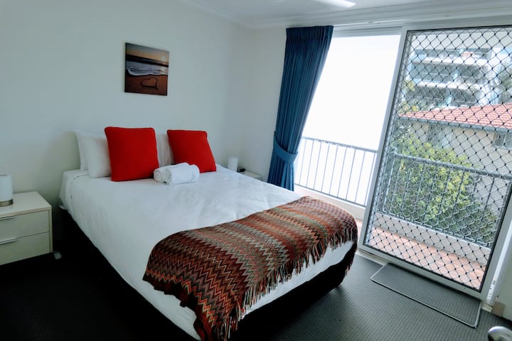 ห้องนอนที่ 2 พร้อมเตียงควีนไซส์ตู้เสื้อผ้าที่มีกระจกและระเบียงส่วนตัว