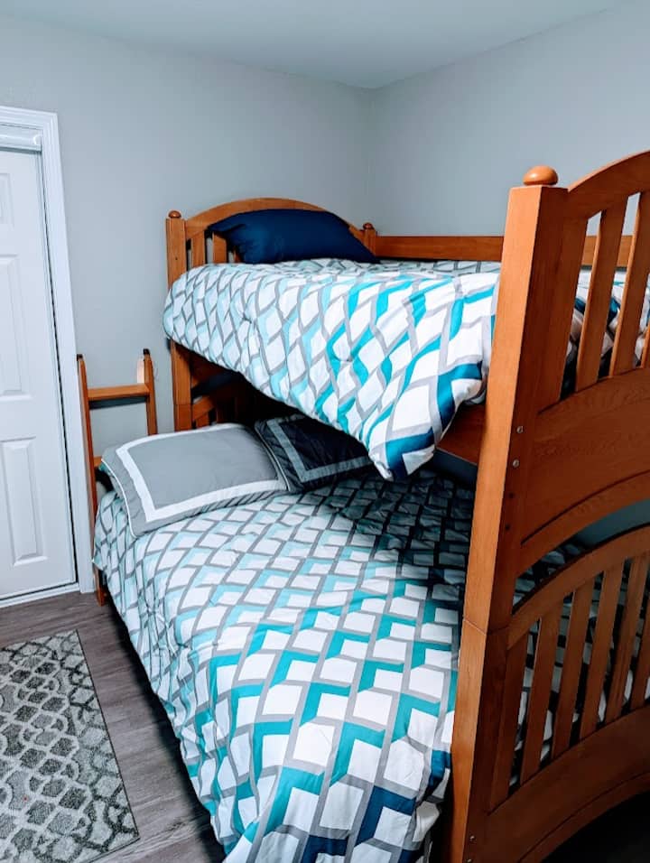 Spálňa č.3.  Táto spálňa pre hostí môže ubytovať až 5 hostí s dvojlôžkom nad plnou poschodovou posteľou a extra manželskou posteľou. Má tiež inteligentný televízor a šatník. Ideálne pre rodiny alebo skupiny.