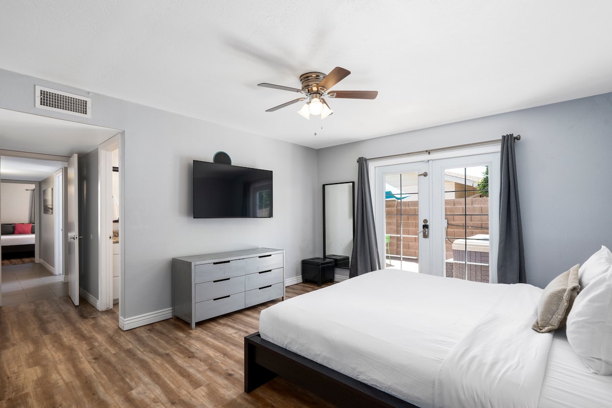 La chambre principale dispose également d'une télévision connectée, d'une commode, de beaucoup d'espace dans le placard. Et les magnifiques portes-fenêtres s'ouvrent sur le jacuzzi et la table du patio !