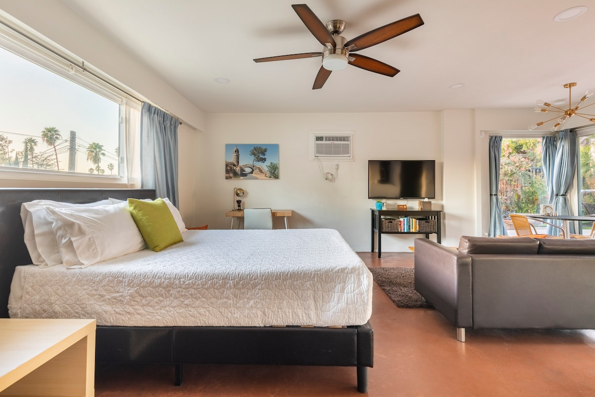 Living area, bed, work station with desk lamp.