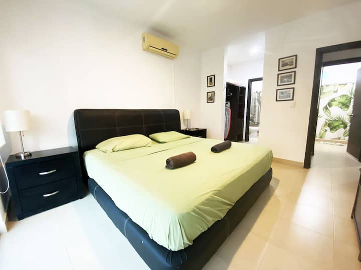 The master bedroom with a king size bed, large smart TV, air conditioning, its own bathroom and private indoor garden view
