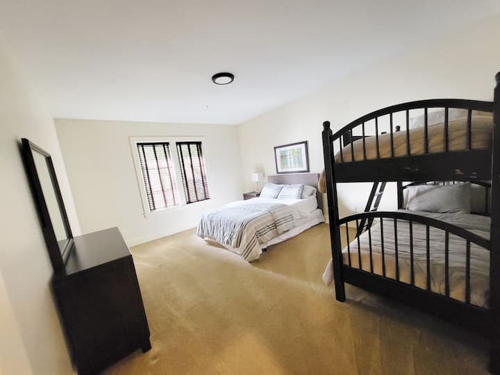 Upstairs Bedroom #6 with a queen bed and bunk beds in a large spacious and bright room.  Sleeps 4 