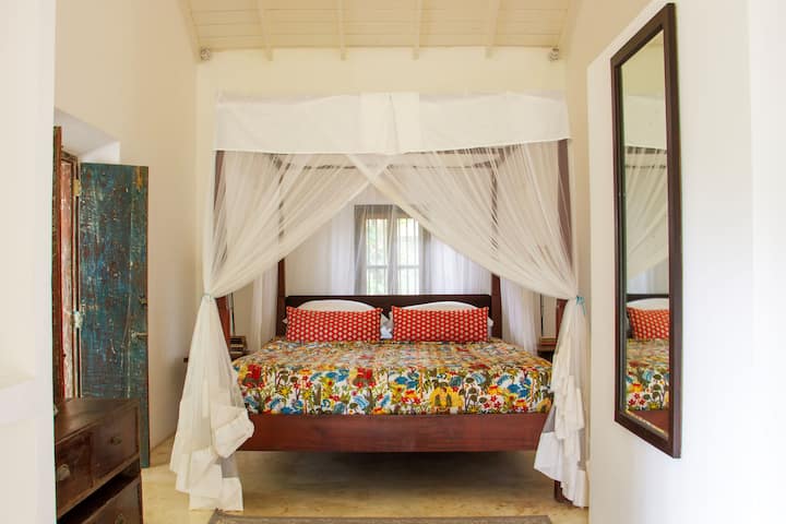 Bedroom 2 - Light and airy room with kingsize 4 poster bed, with mosquito net has views over the tropical garden and has 2 large cupboards for clothese storage. There is an en suite bathoom with shower. There is also a small sitting room