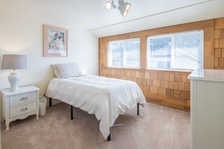 חדר שינה למעלה, מיטה זוגית עם שידה.  