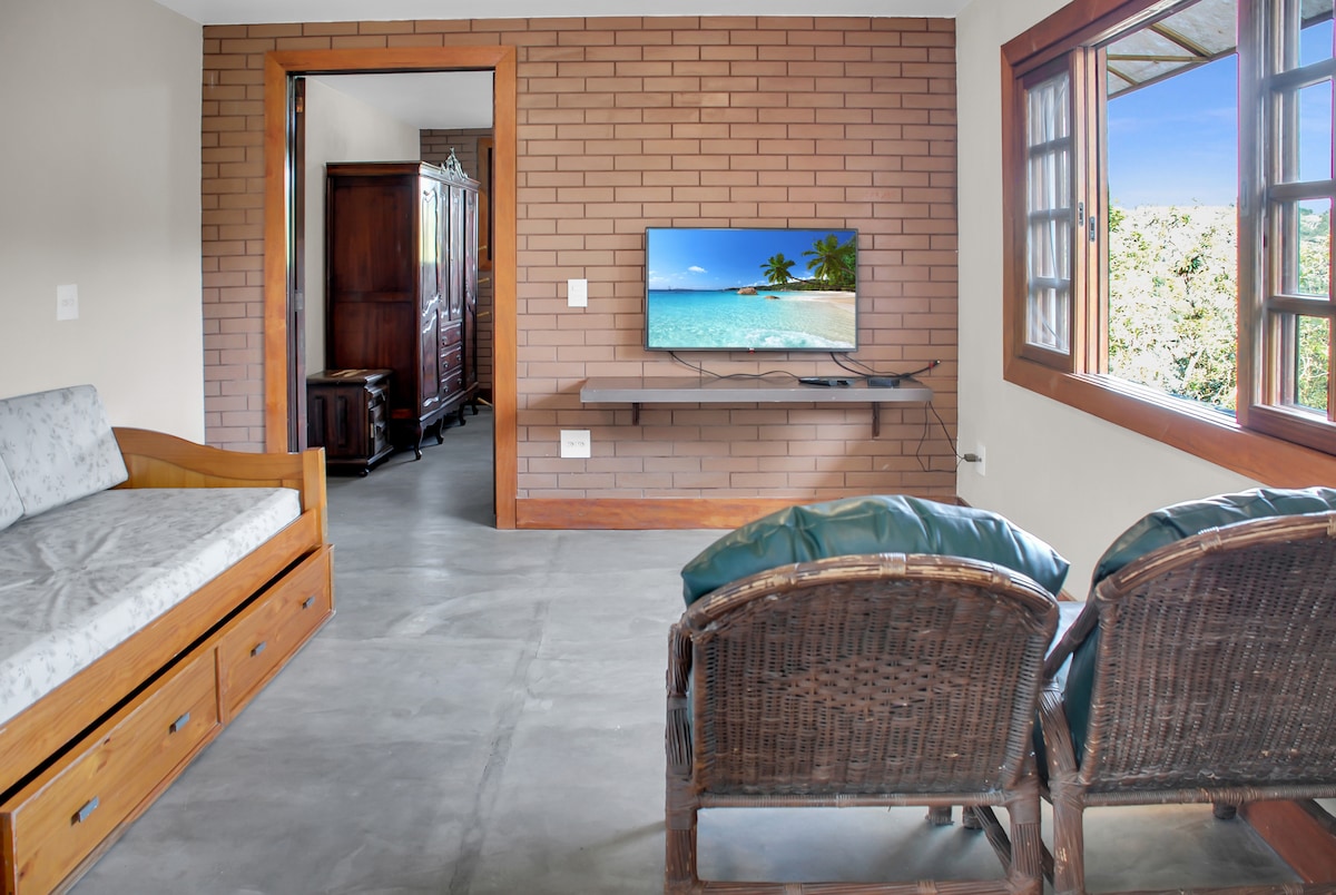 Cocina con mesa de comedor, sofá cama, sillas y TV justo al lado.