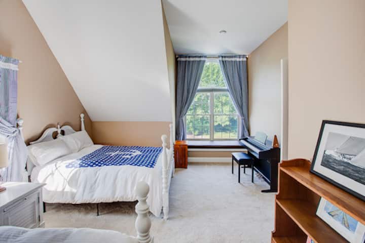 ห้องนอนชั้นบนพร้อมวิวที่นั่งเปียโนและม้านั่งทางทิศตะวันตก