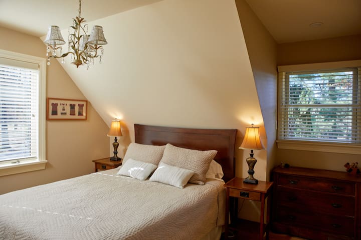 Chambre à l'étage lit queen size, commode complète et placards.  La fenêtre avant a une vue sur la montagne. Une salle de bain complète se trouve juste en face de cette chambre.