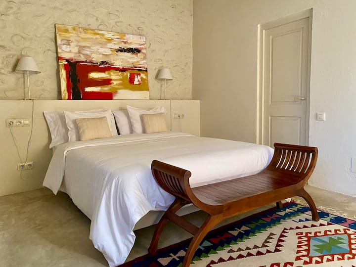 A bedroom with a double bed with access to the bathroom.