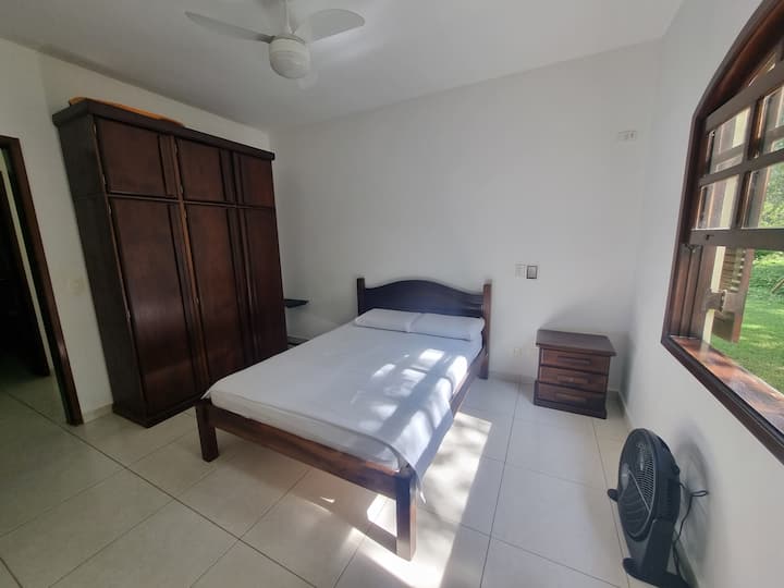 Chambre double avec serviteurs muets, placard et ventilateur au plafond et ventilateur au sol.