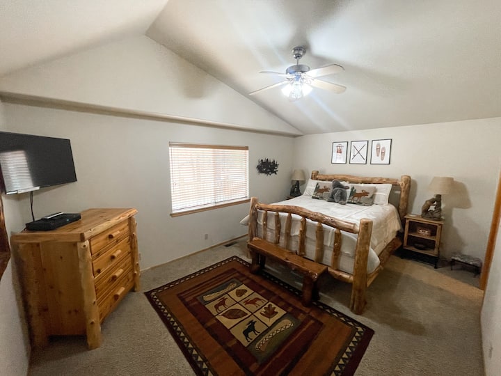 Suite principal que está escondida en el lado opuesto de la cabaña de los otros dos dormitorios. Cuenta con una cama California King de alta calidad, TV de pantalla plana, baño privado, vistas al porche trasero y vestidor.