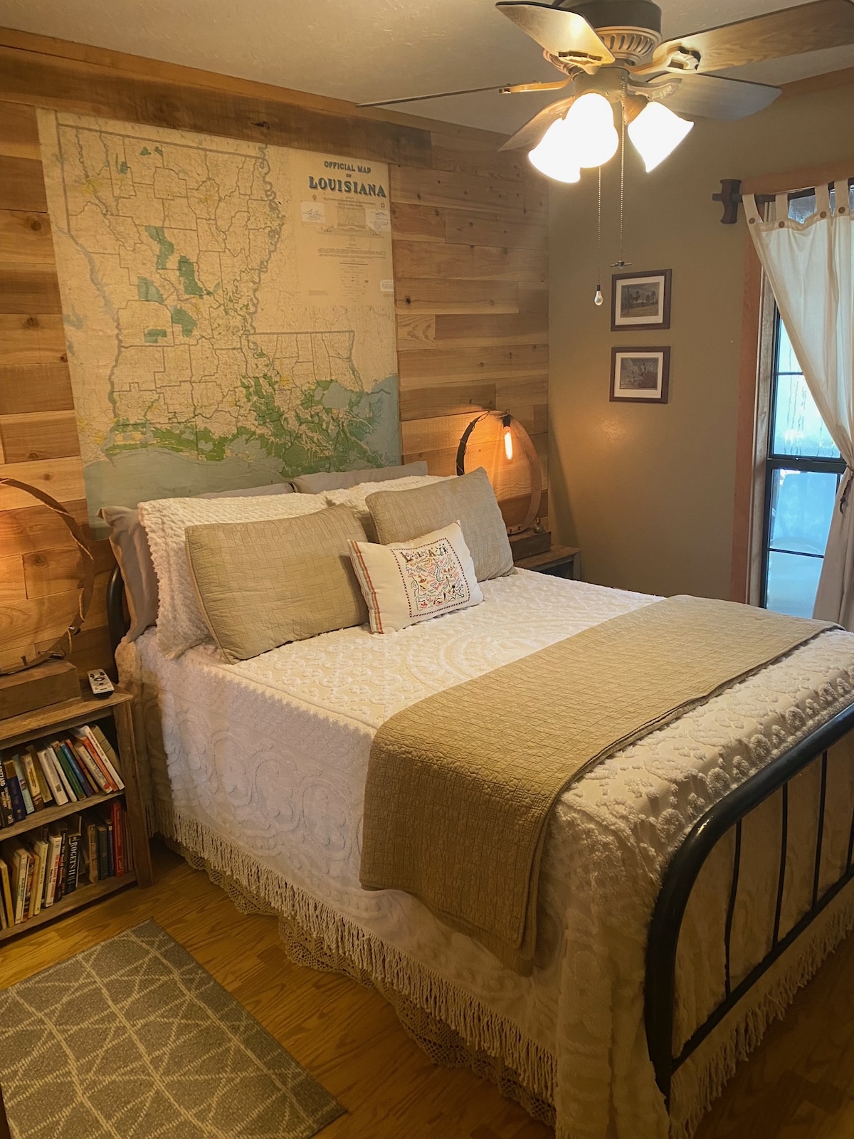 Dormitorio en la planta baja con una cama de tamaño completo y lámparas personalizadas.