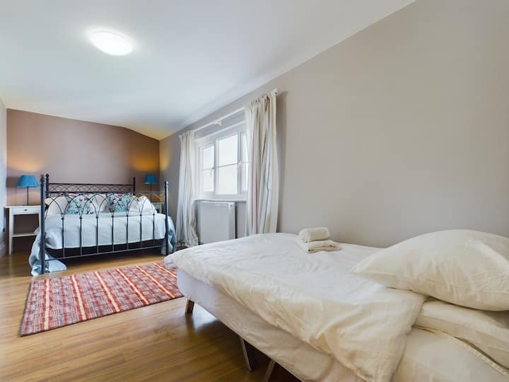 Suíte familiar com uma cama de casal e uma cama de solteiro localizada no primeiro andar.