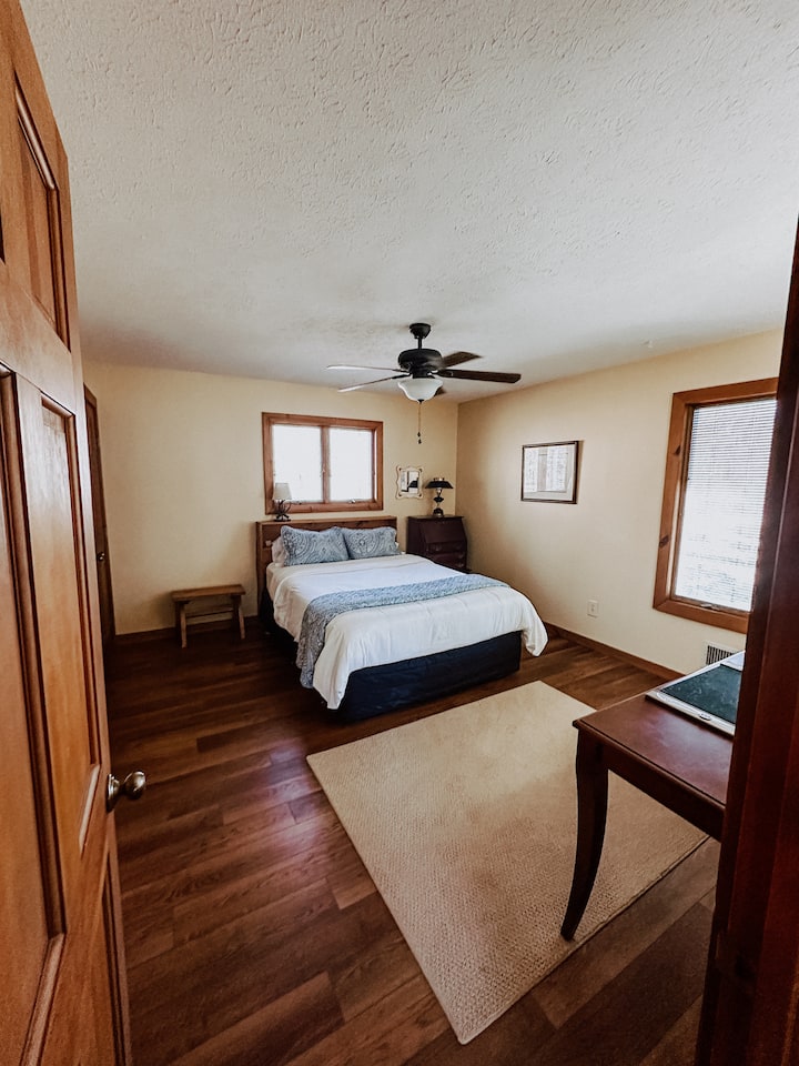 Queen-sized bed with ceiling fan in BR 1