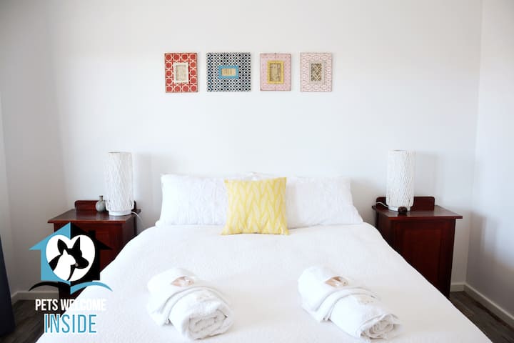 Dormitorio con cama tamaño queen y albornoces empotrados