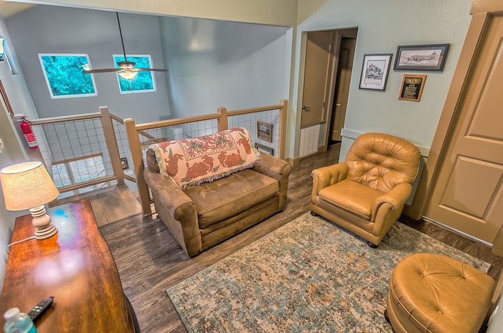 Upstairs loft area with twin sofa sleeper, TV and fireplace.