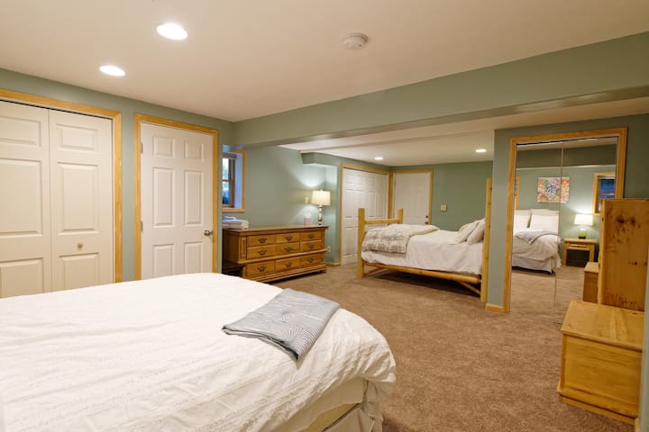 Large cozy downstairs bedroom with Queen bed, Full bed and chest with toys and books for kids. Also, has a door with access to the hot tub outside.