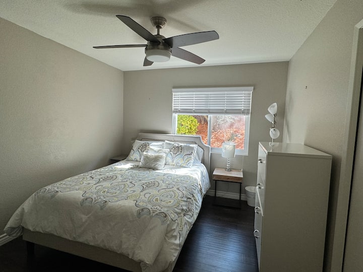 Dormitorio en la planta baja con ventilador de techo y baño