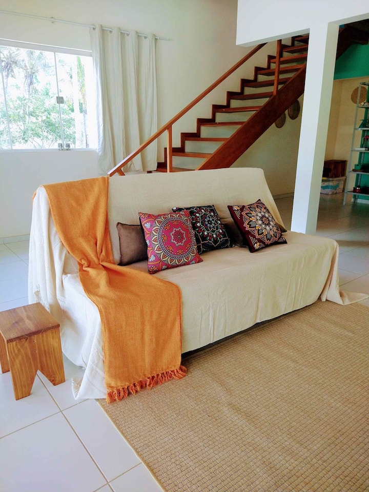 נוף חלקי של הסלון עם ספה נפתחת זוגית - מדרגות מאחור מובילות לסוויטה למעלה