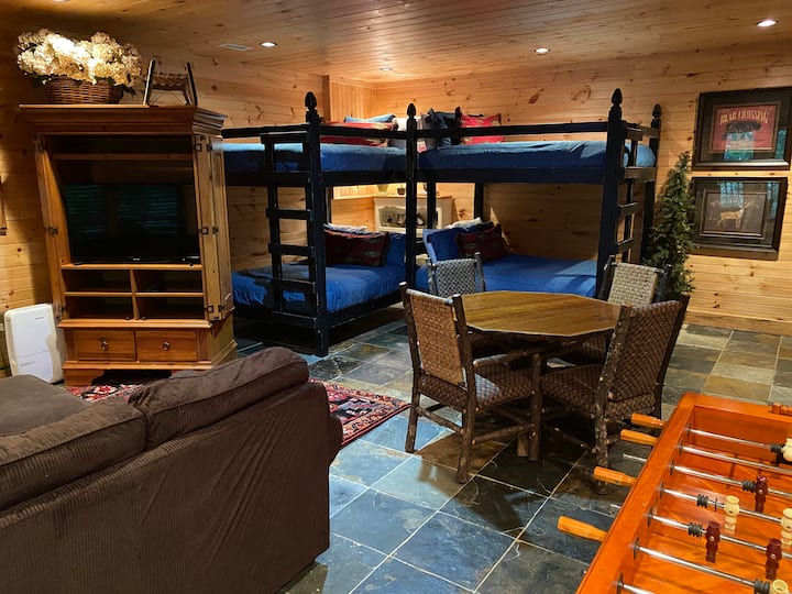 Bekvämt, öppet vardagsrum på nedervåningen med våningssängar i full storlek, foosball, etc.