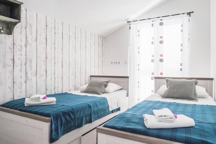 Chumba kidogo chenye vitanda viwili vya mtu mmoja.